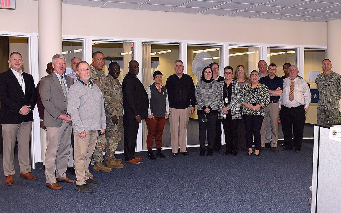 A group of people pose for a photo in an office space.