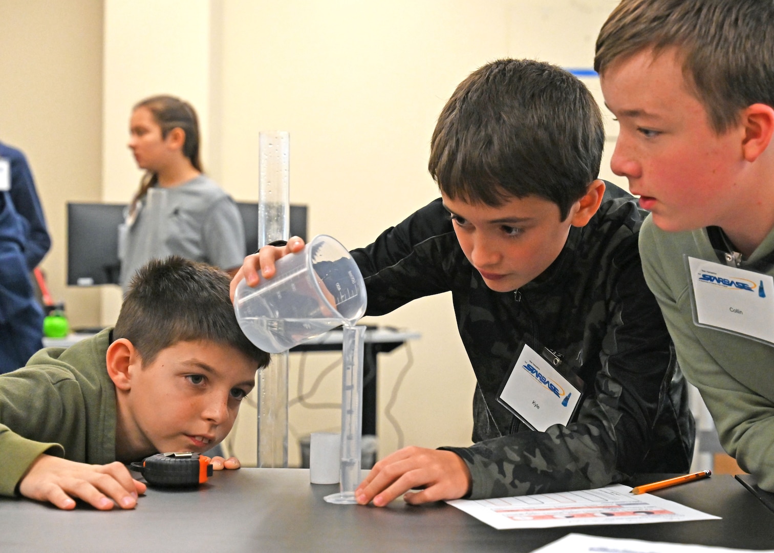 From left, Jaxson Mailhot, Kyle Tassias, and Collin Meaney of Dunbarton Elementary School conduct a science experiment Nov. 13, 2023, at the New Hampshire National Guard’s Edward Cross Training Complex in Pembroke.