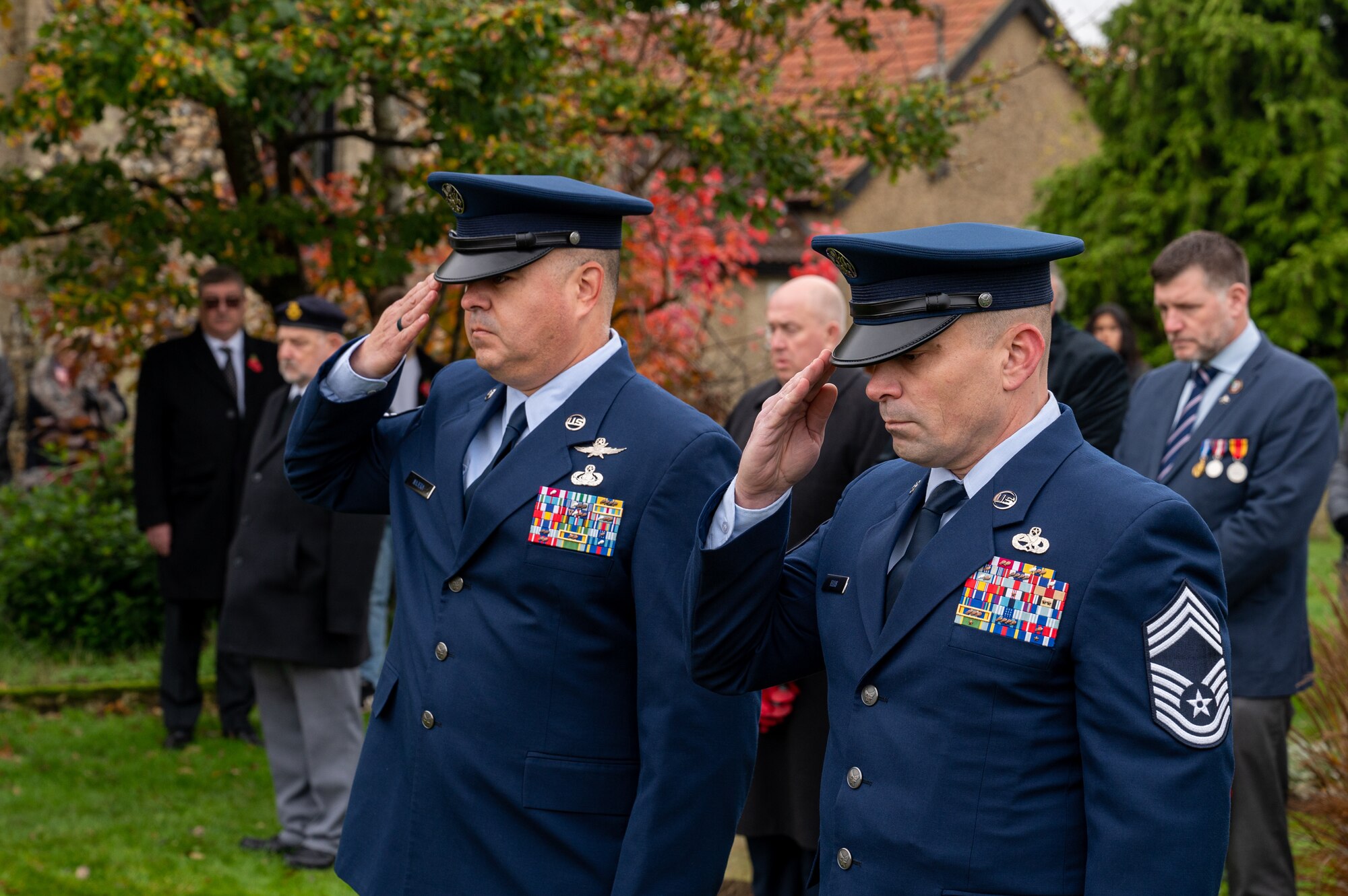 U.S. Air Force Chief Master Sgt. David Najera, left, 100th Communications Squadron senior enlisted leader and Chief Master Sgt. Joel Ellis, right, 752nd Special Operations Aircraft Maintenance Squadron senior enlisted leader, salute during a Remembrance Day ceremony, Beck Row, England, Nov. 12, 2023.