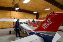 Civil Air Patrol Lt. Col. Stephen Sammons, left, Alaska Wing emergency services officer, instructs CAP cadets from the Southcentral Region where to find an Emergency Locator Transmitter onboard a Cessna 172 aircraft during a three-day training event Nov. 4, 2023, at the Birchwood Airport in Chugiak, Alaska.