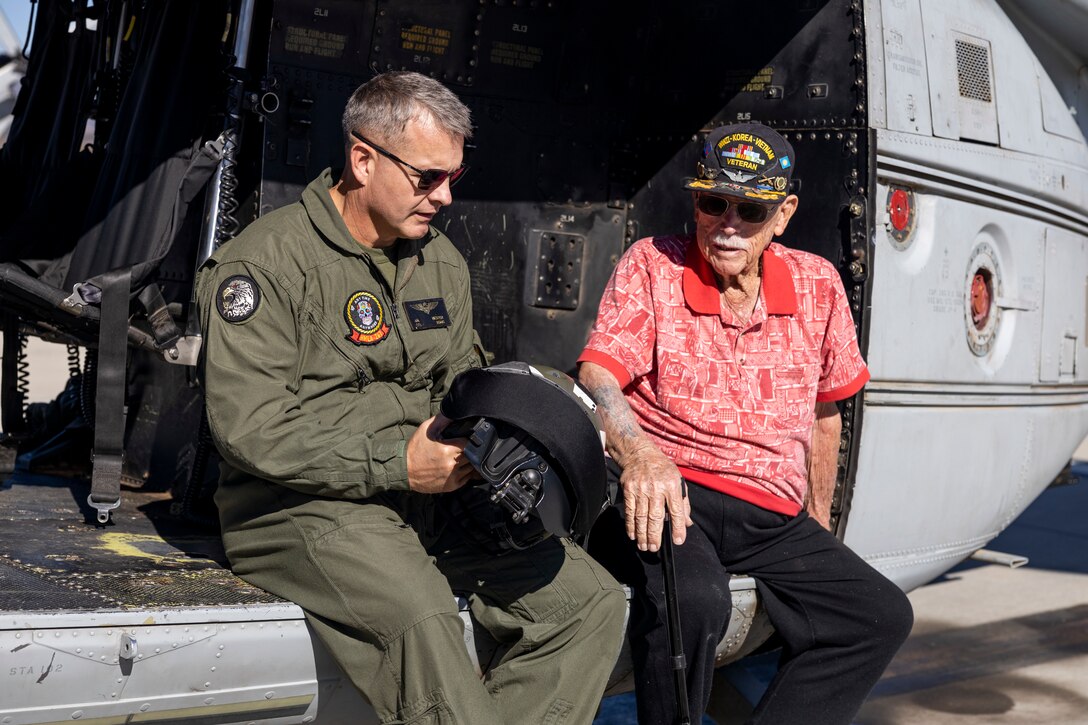 U.S. Marine Corps Col. Jeremie Hester, left, commanding officer of Marine Aircraft Group 39, 3rd Marine Aircraft Wing, discusses the advancements made in modern pilot helmets with retired U.S. Marine Corps and Army veteran Maj. Billy Hall in a UH-1Y Venom with Marine Light Attack Helicopter Squadron (HMLA) 267, MAG-39, 3rd MAW, before an honor flight at Marine Corps Air Station Camp Pendleton, California, Nov. 11, 2023. The 97-year-old veteran of World War II, Korea, and Vietnam celebrated the 82nd Anniversary of his Marine Corps Recruit Training graduation by flying with the Marines of HMLA-267. (U.S. Marine Corps photo by Sgt. Sean Potter)
