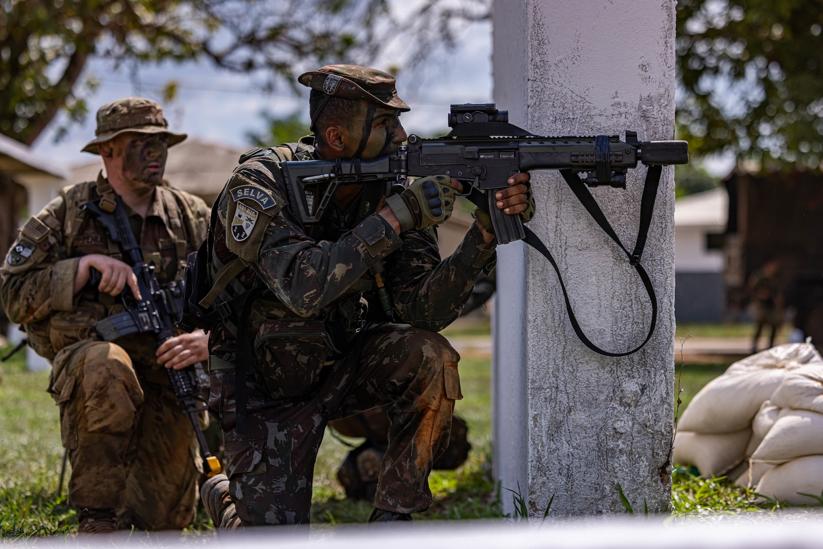 Brazilian soldiers search a man looking for guns at the entrance