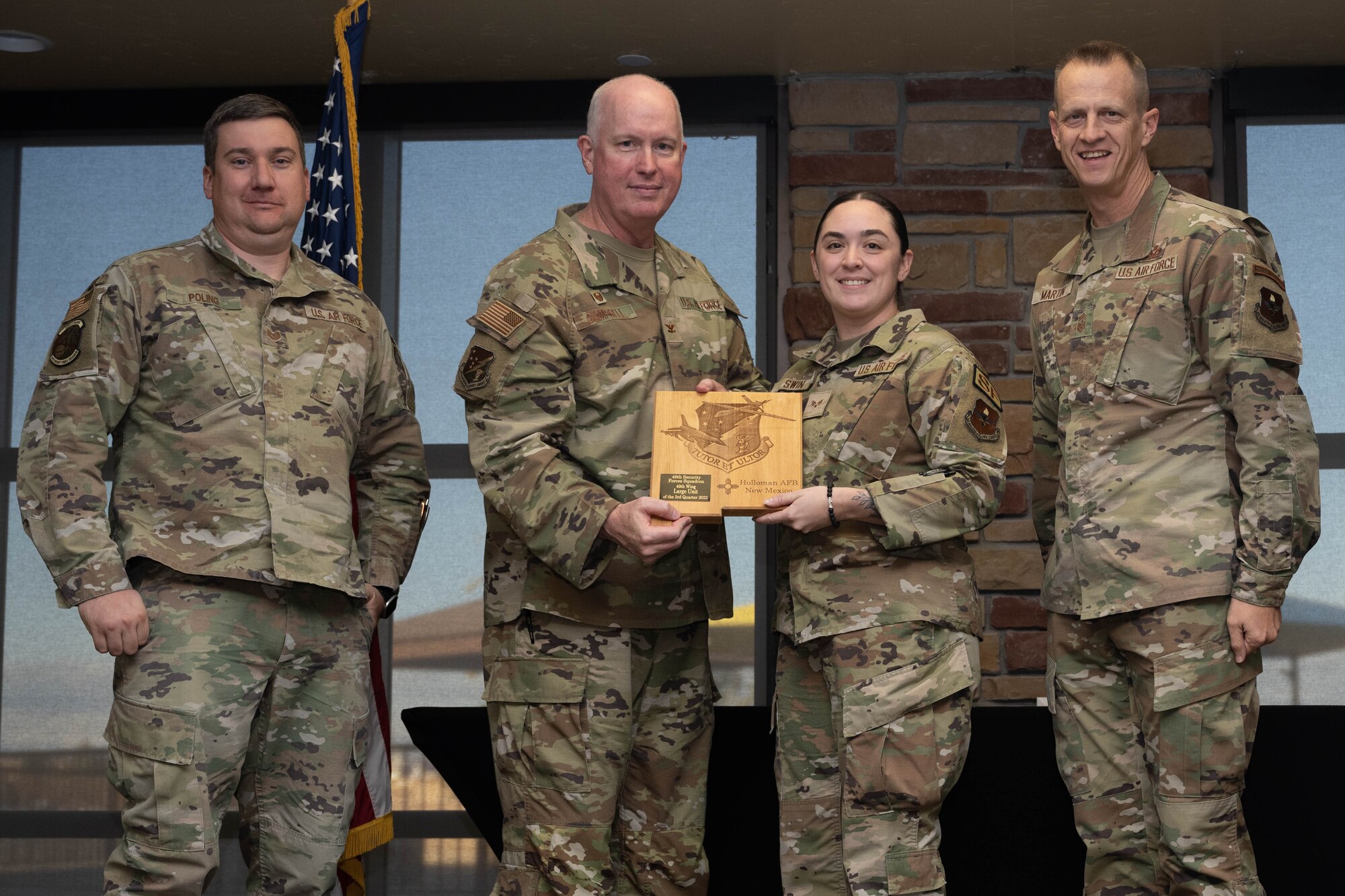 U.S. Air Force Senior Airman Brittany Swin from the 49th Security Forces Squadron, center, accepts the Large Unit of the Quarter award for the 49th SFS during the 49th Wing’s 3rd Quarter Award ceremony at Holloman Air Force Base, New Mexico, November 9, 2023. Quarterly award winners were selected based on their technical expertise, demonstration of leadership and job performance. (U.S. Air Force photo by Airman 1st Class Bob Teichmann)