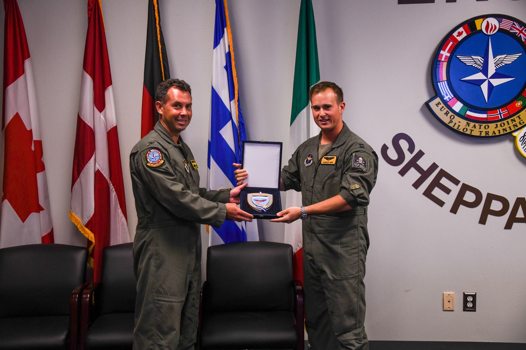 Two Air Force pilot hold a plaque