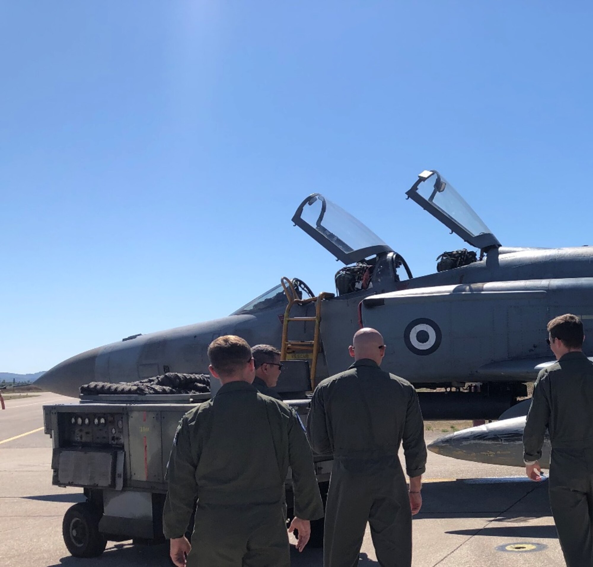 Pilots stand in front of a jet