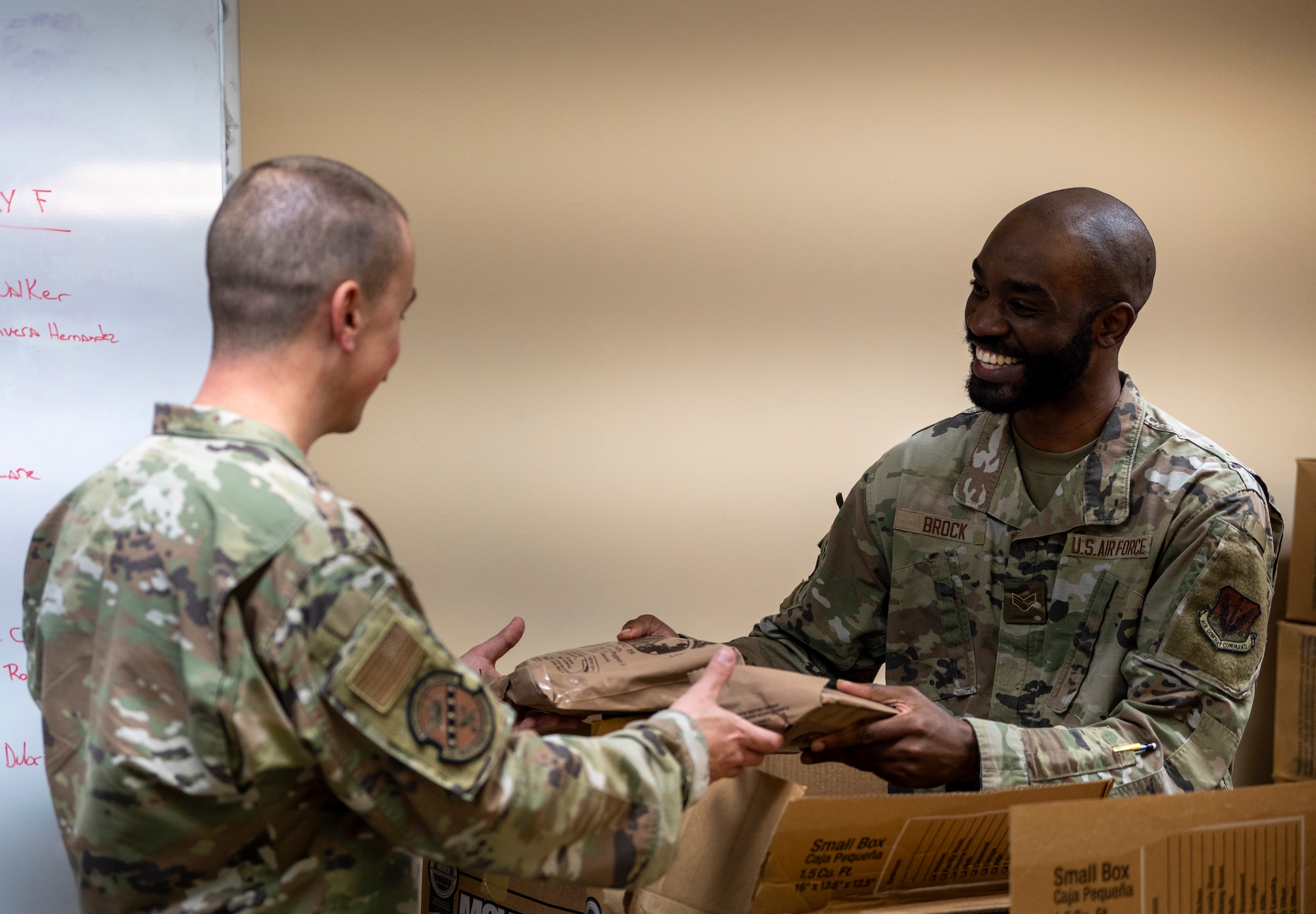 U.S. Air Force Senior Airman Derek Brock, Personnel Support for Contingency Operations lodging manager, gives out Meals Ready to Eat to Mosaic Tiger 24-1 exercise participant at Avon Park Air Force Range, Florida, Nov. 13, 2023. MREs are a staple for troops deployed to austere environments. (U.S. Air Force photo by Airman 1st Class Leonid Soubbotine)