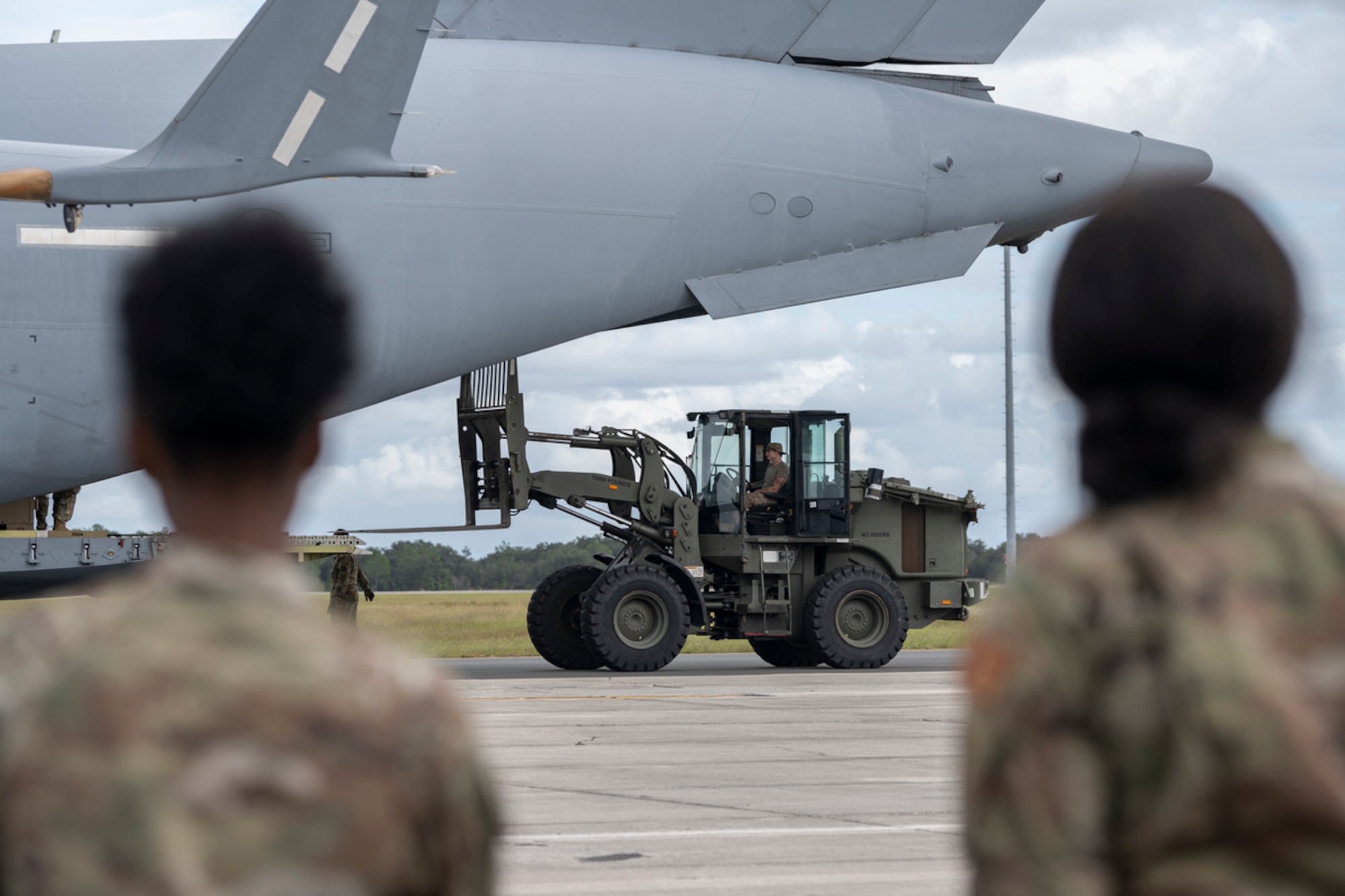 A U.S. Air Force Airman assigned to the 23rd Logistic Readiness Squadron ground transportation flight unloads pallets from a C-17 Globemaster III during exercise Mosaic Tiger 24-1 at Avon Park Air Force Range, Florida, Nov. 13, 2023. The pallets consisted of participant’s personal luggage, protective gear and flightline equipment. (U.S. Air Force photo by Senior Airman Rachel Coates)