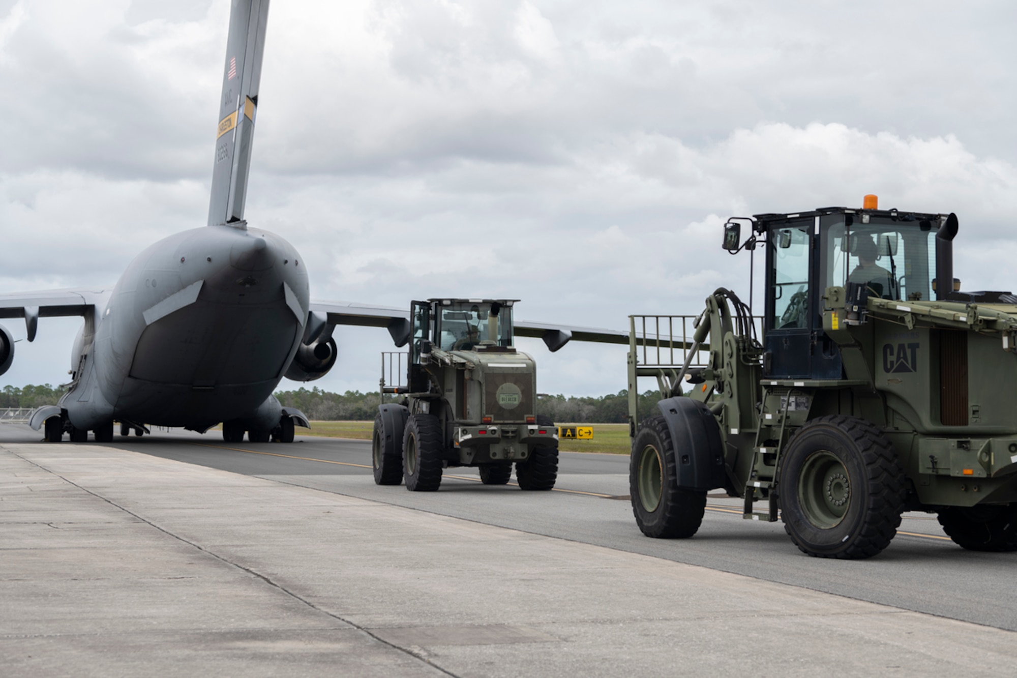 U.S. Air Force Airmen assigned to the 23rd Logistic Readiness Squadron ground transportation flight stand by to unload a C-17 Globemaster III during exercise Mosaic Tiger 24-1 at Avon Park Air Force Range, Florida, Nov. 13, 2023. MT24-1 is a readiness exercise designed to hone Moody’s ability to conduct combat operations in austere locations with degraded communications. (U.S. Air Force photo by Senior Airman Rachel Coates)