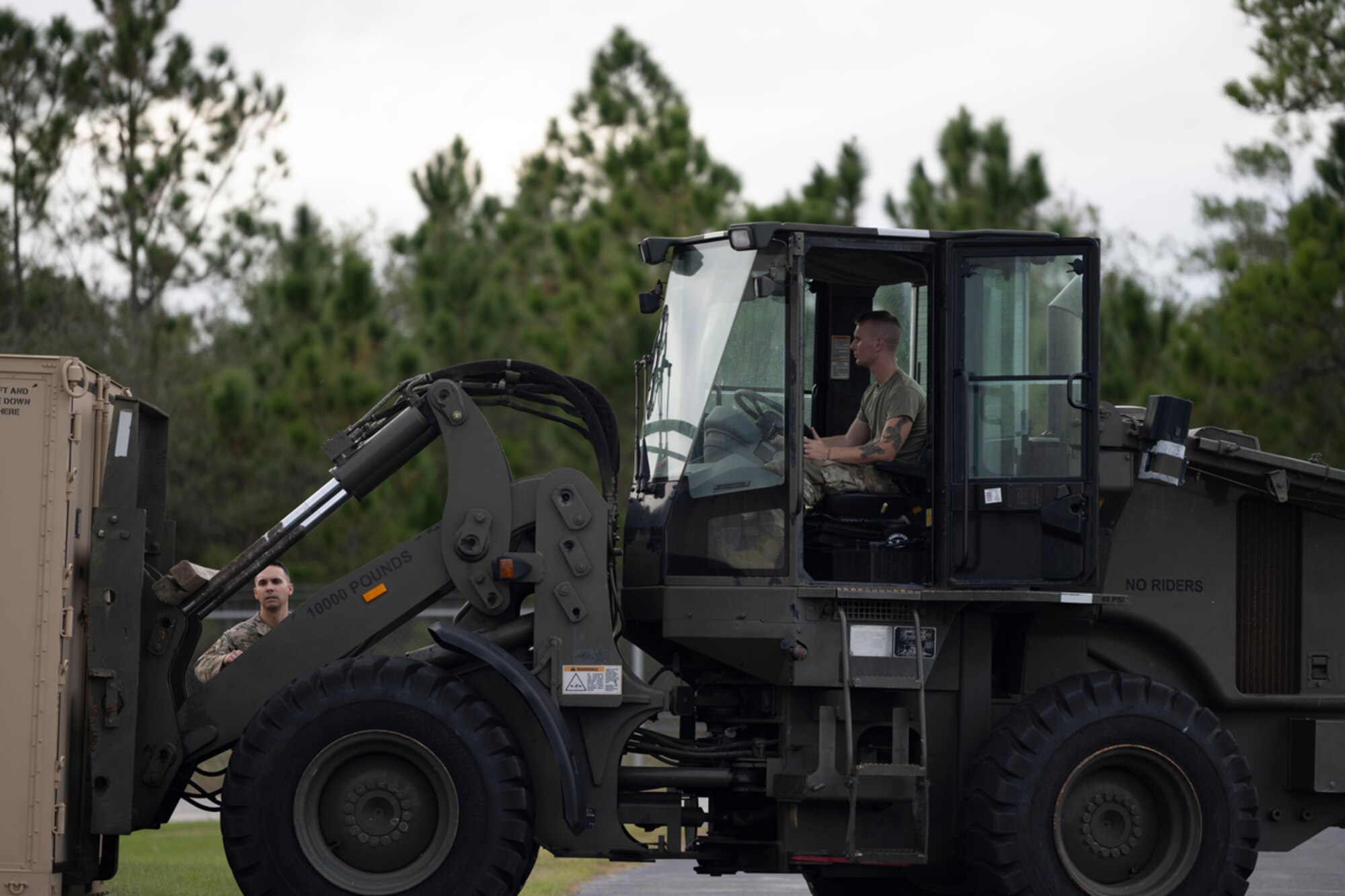 A participant of exercise Mosaic Tiger 24-1 transports a shipping container at Avon Park Air Force Range, Florida, Nov. 13, 2023. The container was filled with communication equipment needed for transmitting information to the main operating base, located at Moody Air Force Base, Georgia. (U.S. Air Force photo by Senior Airman Rachel Coates)