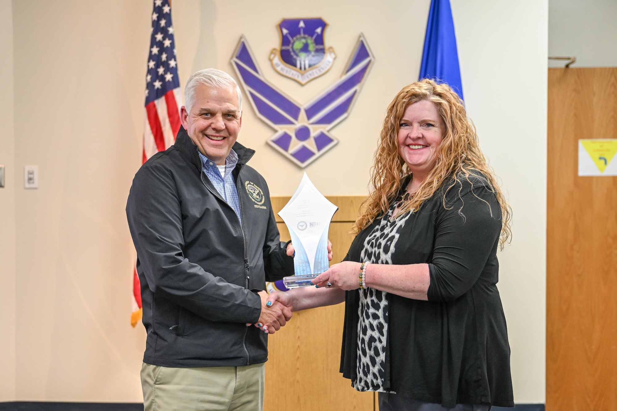 Lowman and Betz stand holding the DoD award.