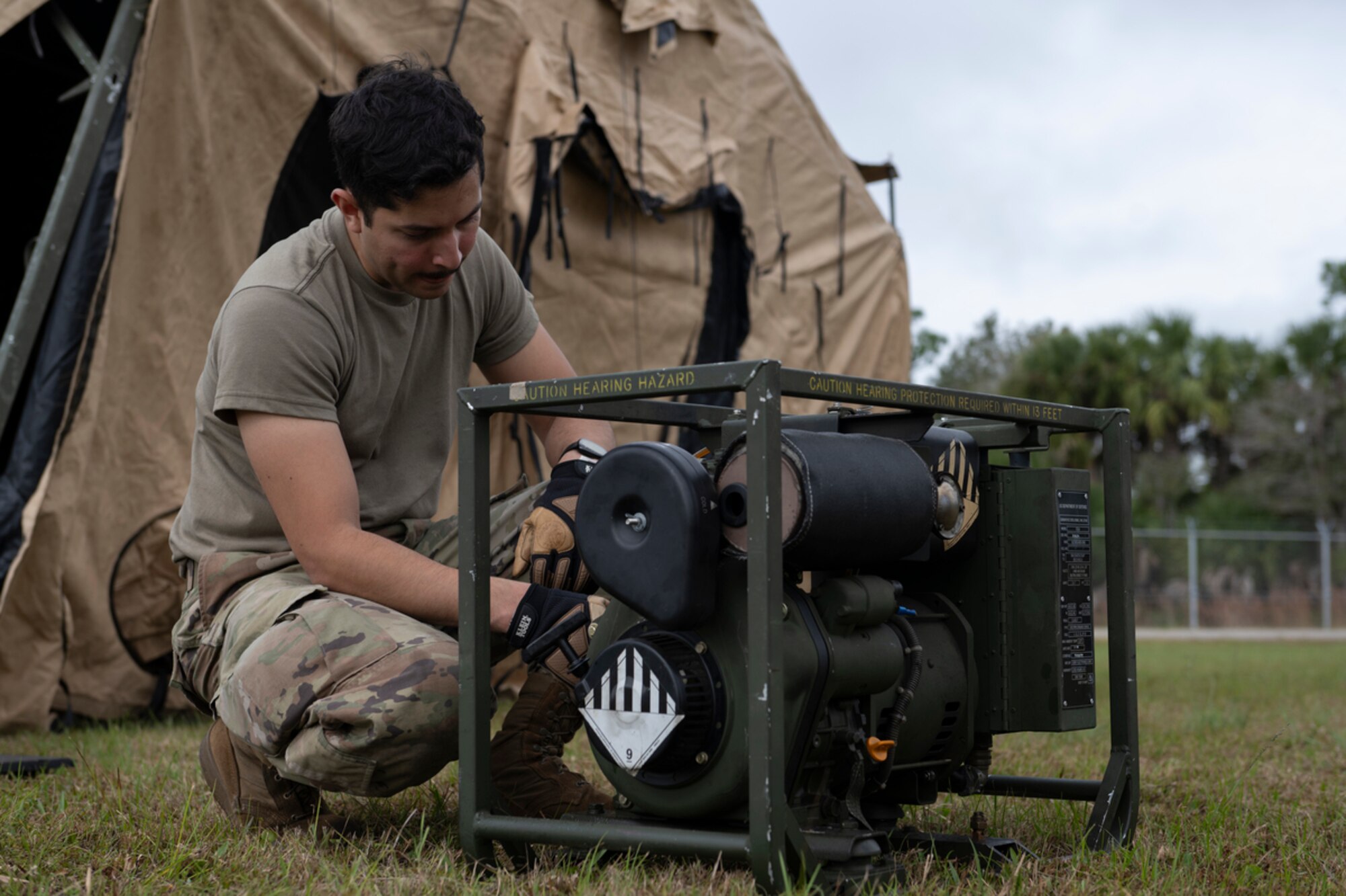 U.S. Air Force Airman Alejandro Vargas-Carrasco, 23rd Civil Engineer Squadron generator technician, examines a generator during exercise Mosaic Tiger 24-1 at Avon Park Air Force Range, Florida, Nov. 14, 2023. The generator will be used to power a single pallet expeditionary kitchen. (U.S. Air Force photo by Senior Airman Rachel Coates)