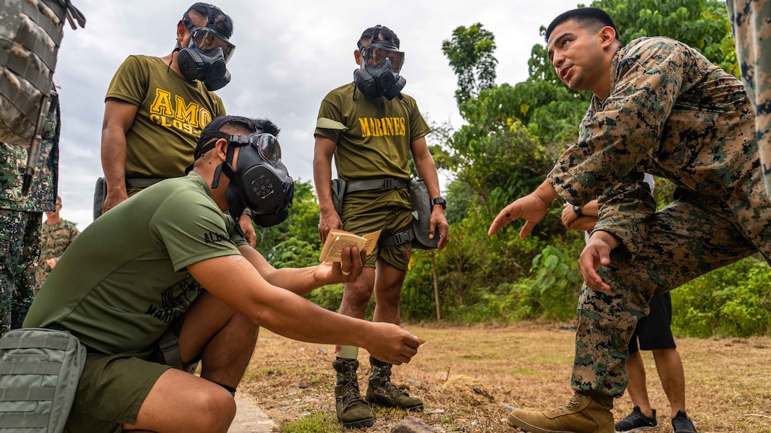 U.S. Marine Corps Sgt. Johnathan Berry, right, a chemical biological radiological nuclear responder with Marine Rotational Force-Southeast Asia, I Marine Expeditionary Force, gives a period of instruction to members of the Philippine Marine Corps on the proper use of M8 agent detection paper while at a CBRN subject matter expert exchange during KAMANDAG 7, in Zamboanga, Philippines, Nov. 12, 2023. KAMANDAG is an annual Philippine Marine Corps and U.S. Marine Corps-led exercise aimed at improving readiness, alliances, and mutual capabilities in the advancement of a Free and Open Indo-Pacific. This year marks the seventh iteration of this exercise and includes participants from Japan, the Republic of Korea, and observers from the United Kingdom. MRF-SEA is a Marine Corps Forces Pacific operational model which involves planned exchanges with subject matter experts, promotes security goals with Allies and partners, and positions I MEF forces west of the International Date Line. (U.S. Marine Corps photo Cpl. By Dean Gurule)