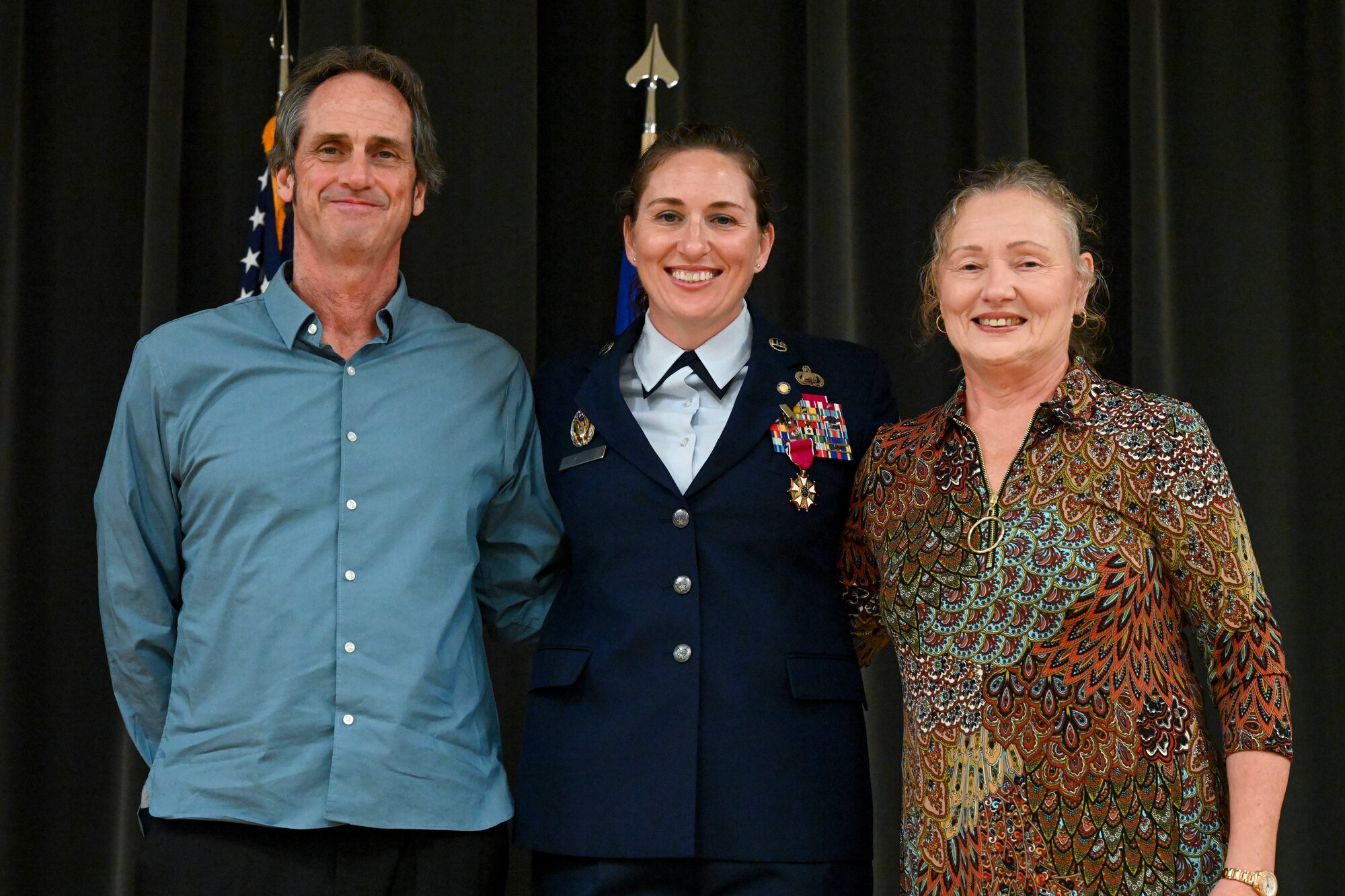 Chief Master Sgt. Heather Stanfield, 19th Mission Support Group senior enlisted leader, poses for a photo with her parents during a retirement ceremony