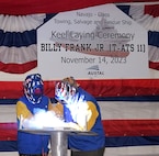 Billy Frank Jr. (T-ATS 11) Ship Sponsor Peggen Frank (at left) looks on as Austal welder Brandon Auld traces her initials onto a ceremonial keel plate.