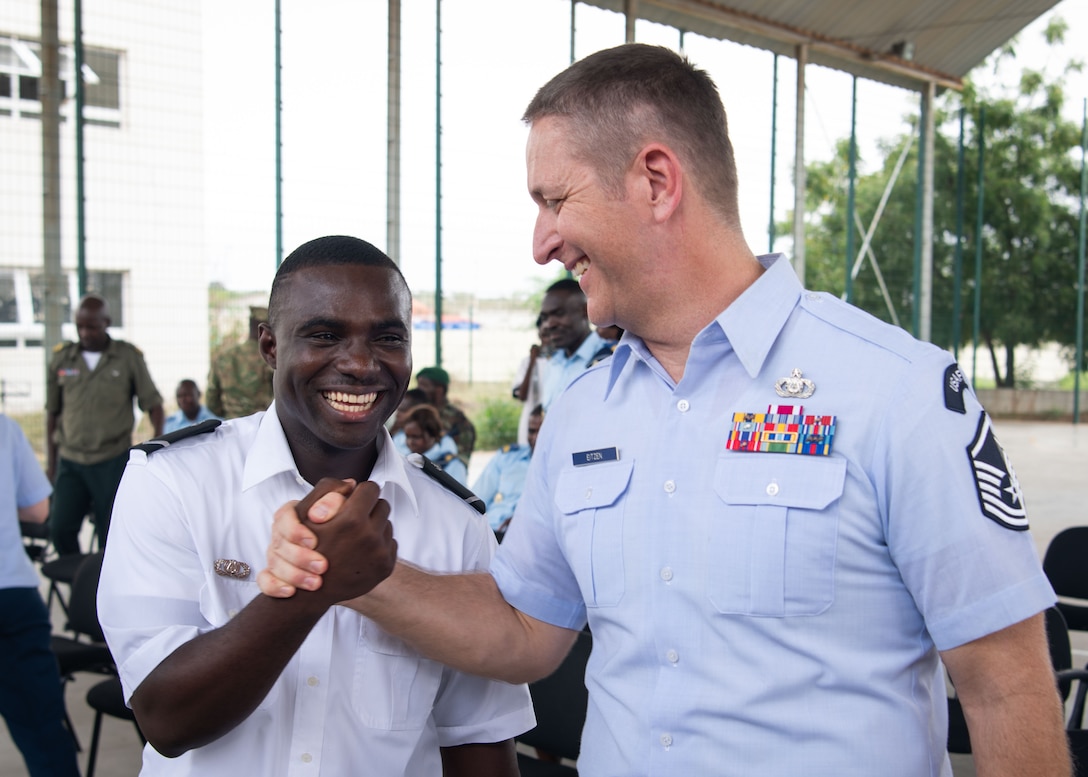 U.S. Air Force Master Sgt. Carl Eitzen, right, assigned to the U.S. Air Forces in Europe and Air Forces Africa (USAFE-AFAFRICA) Band’s 5 Star Brass, shakes hands with Marinheiro Garcia Da Costa, assigned to the Angolan Armed Forces Band, during a performance at the Polytechnic Institute of Art in Kilamba, Angola, Nov. 9, 2023. The USAFE-AFAFRICA Band’s tour to Angola embodies the U.S. Air Forces Africa’s dedication to strengthening cultural ties and enriching the partnerships between the U.S. and Angola through music. (U.S. Department of Defense photo by Mass Communication Specialist 2nd Class Michael Hogan)