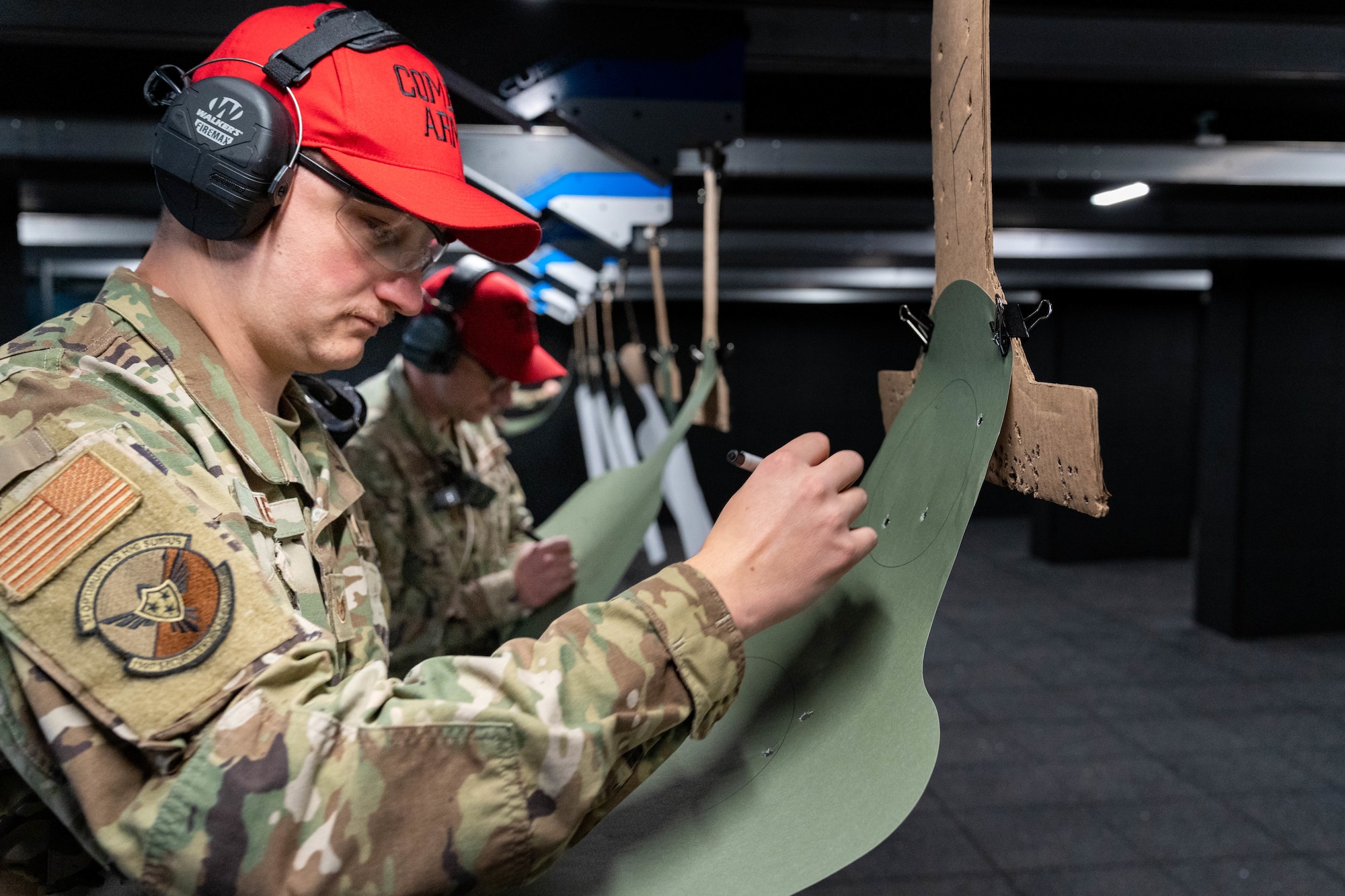 U.S. Air Force Staff Sgt. Jackson Neal, combat arms training and maintenance instructor with the 114th Security Forces Squadron, scores a target during a M18 handgun qualification course at Joe Foss Field, South Dakota, Nov. 4, 2023.