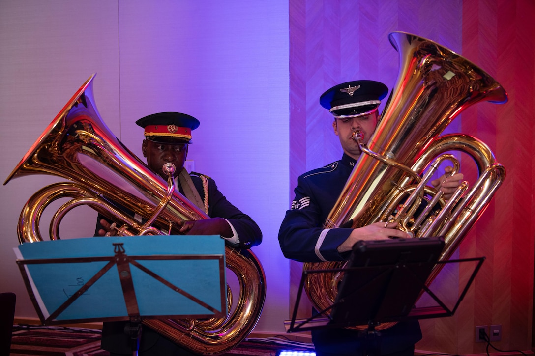 Two uniformed service members play tubas.