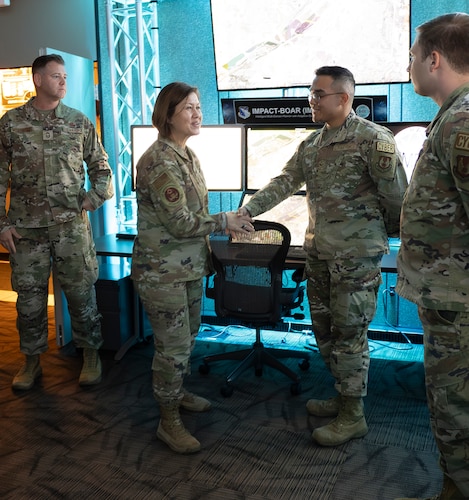 Chief Master Sgt. of the Air Force JoAnne Bass, second from left, shakes hands with Senior Airman Geoffrey Alvarado, autonomous drone operations specialist, 88th Communications Squadron, at a drone program brief during a visit to Wright-Patterson Air Force Base. During the base visit,  she toured the Air Force Research Laboratory’s 711th Human Performance Wing Nov. 9, 2023. (U.S. Air Force photo / Keith Lewis)