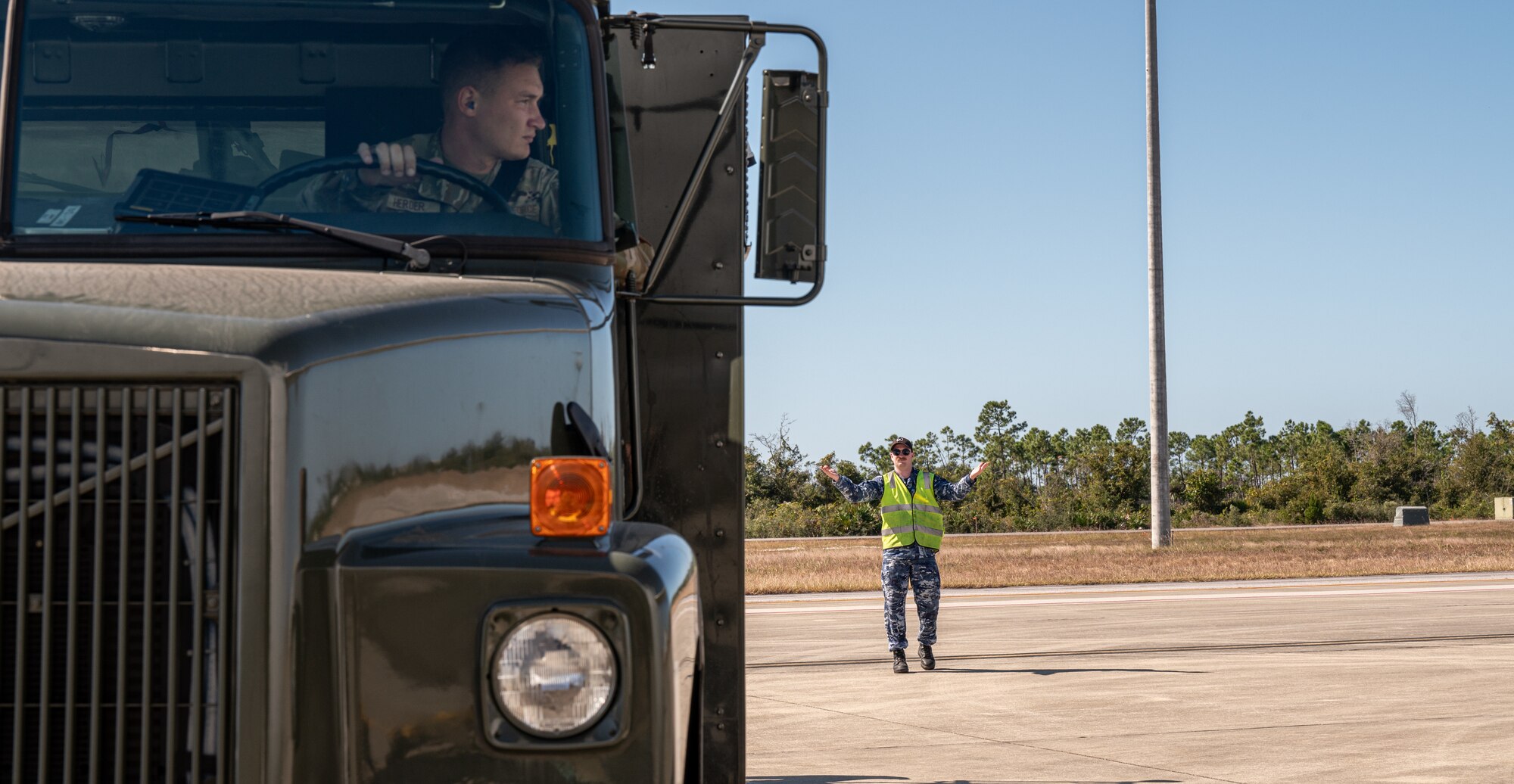 A Royal Australian Air Force Aircraftman assists an Airman