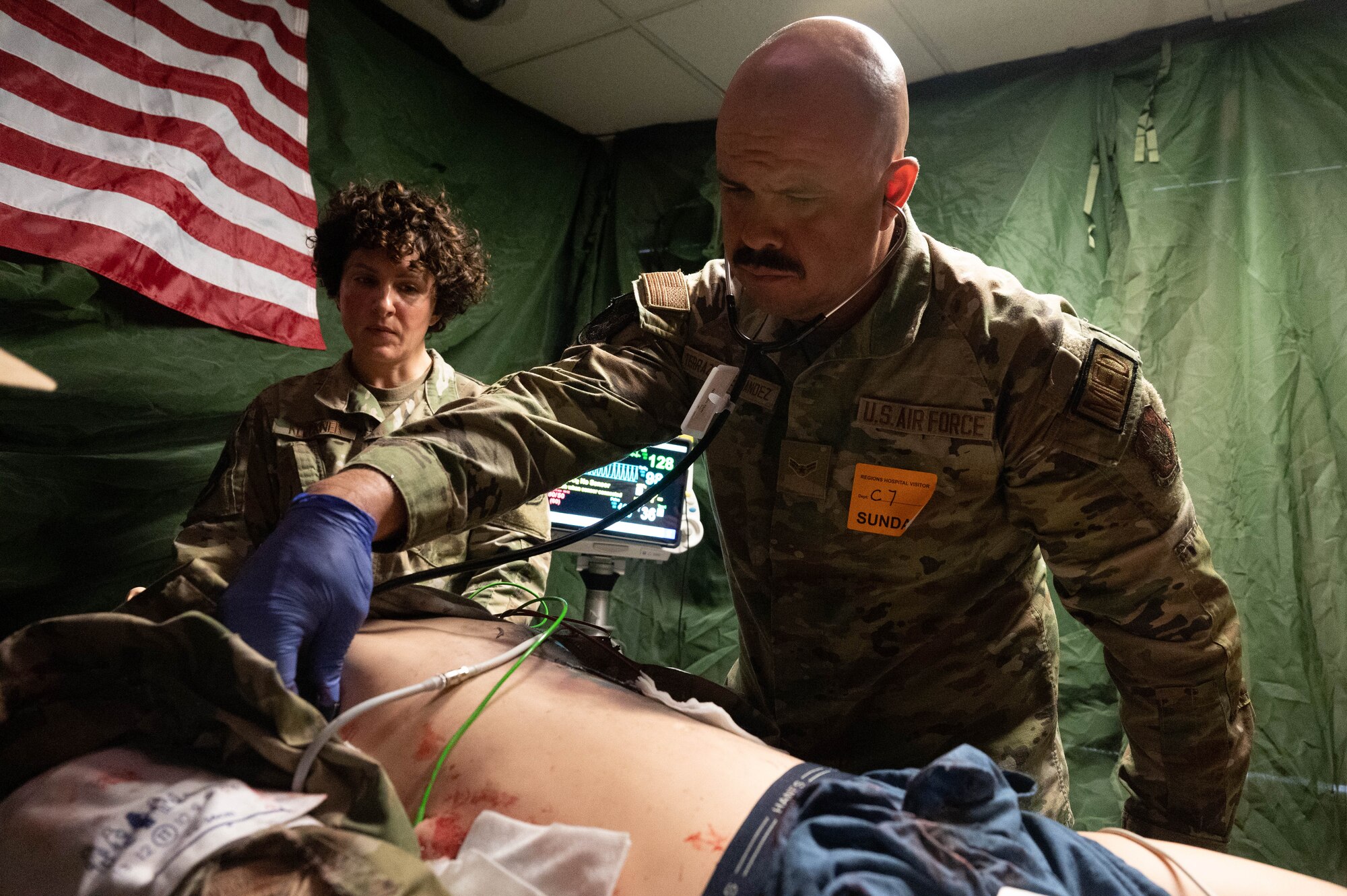 Airman 1st Class Mario Terrazas Hernandez, aeromedical technician at the 934th Airlift Wing, simulates listening to breathing during a training exercise October 15, 2023 at Regions Hospital in St. Paul, Minnesota. The training exercise simulated live casualty care in a combat environment. (U.S. Air Force photo by Senior Airman Victoriya Tarakanova)