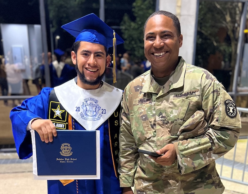 Army Future Soldier holding diploma standing next to Army recruiter on graduation day