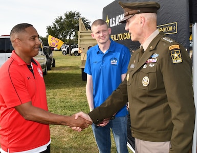 Man wearing Army uniform shakes hands with a man in civilian clothes