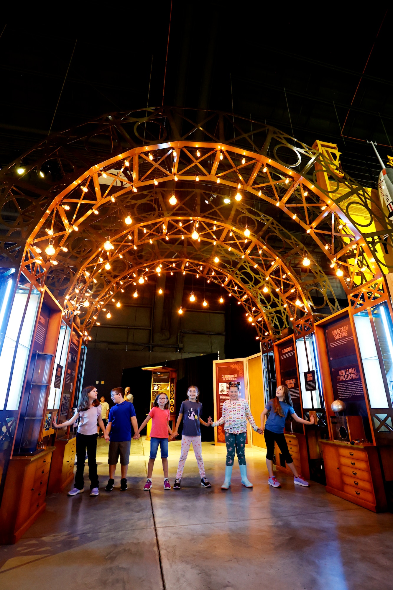 Visitors to the Steampunk exhibit at the National Museum of the U.S. Air Force hold hands to complete a circuit and light-up part of the retro-futuristic experience and create a thunderclap in the Mary Shelley: Ethics and Electricity Gallery. (U.S. Air Force photo by Ty Greenlees)
