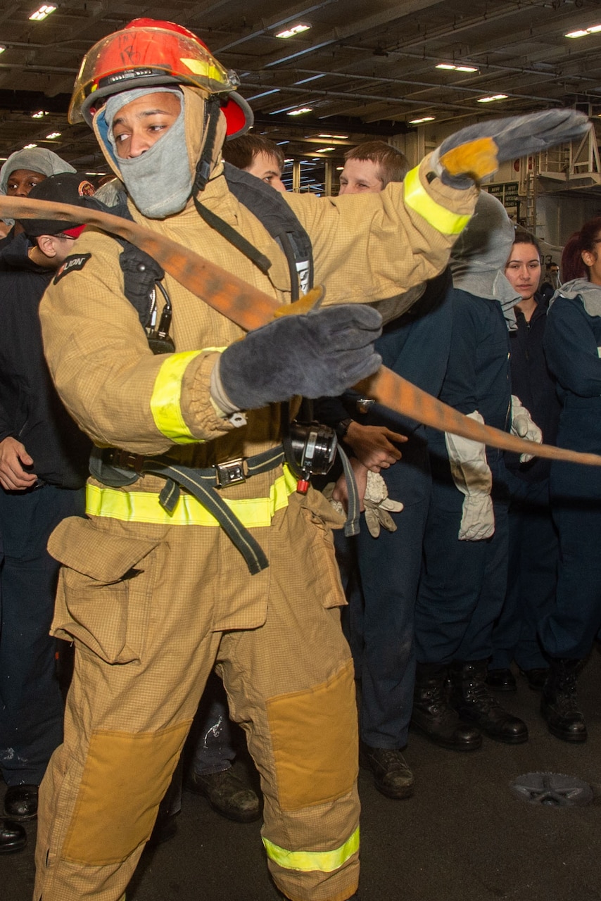 A sailor takes a hose.