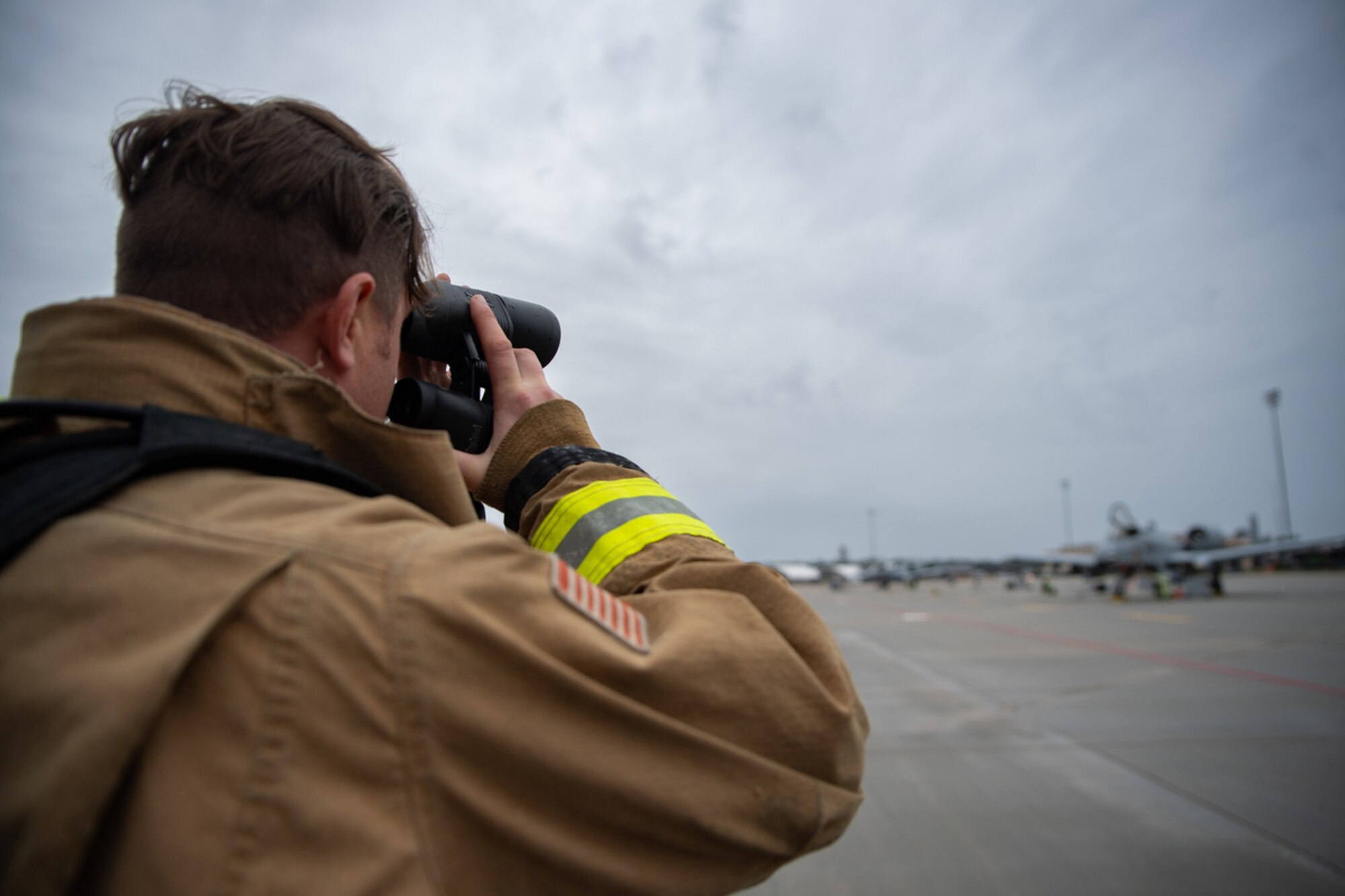 U.S. Air Force Staff Sgt. Logan Williams, 23rd Civil Engineer Squadron firefighter, surveys the area during simulated dropped munition emergency call on the   flightline during exercise Mosaic Tiger 24-1 at Moody Air Force Base, Georgia, Nov. 14, 2023. Firefighters are trained on the dangers of explosive or corrosive materials and assess the situation from the safety of an appropriate cordon before responding. (U.S. Air Force photo by Andrea Jenkins)