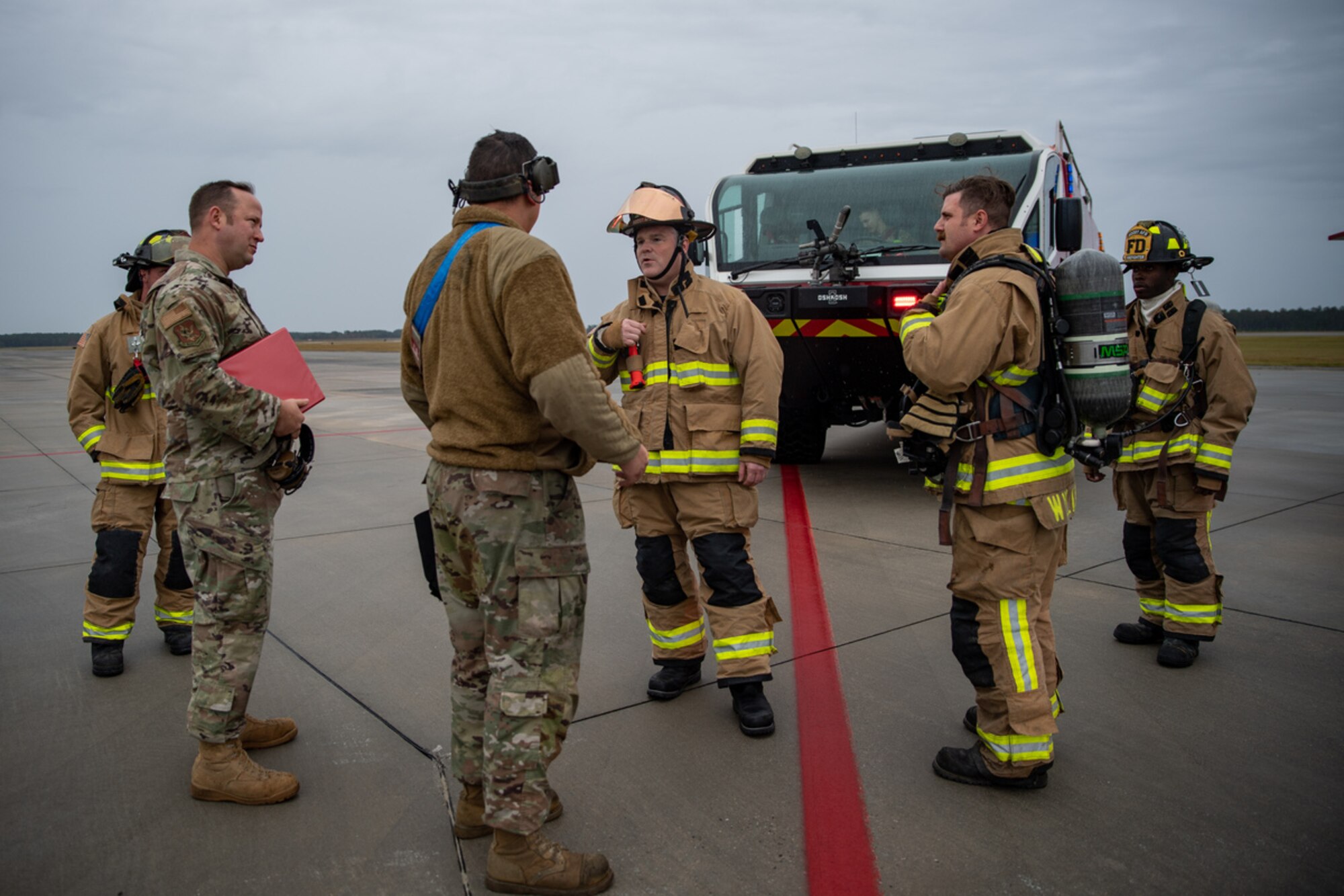 The 23rd Civil Engineer Squadron Fire Department gives the all-clear to U.S. Air Force Staff Sgt. Concepcion Rodelo, 74th Fighter Generation Squadron weapons load crew member, during a simulated dropped munition emergency call on the   flightline during exercise Mosaic Tiger 24-1 at Moody Air Force Base, Georgia, Nov. 14, 2023. After the Airmen complete all the required tasks for the scenario inject, evaluators provide recommended areas of improvement or comment on best practices. (U.S. Air Force photo by Andrea Jenkins)