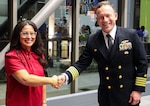 Trident Refit Facility, Bangor (TRFB) team member, Bobbi Worden (left), receives a coin from TRFB commanding officer Michael Eberlein (right), during the 2023 Washington Women in Trades "Dream Big Dinner", Nov. 11, 2023, Shoreline Community College, Shoreline, Washington.
