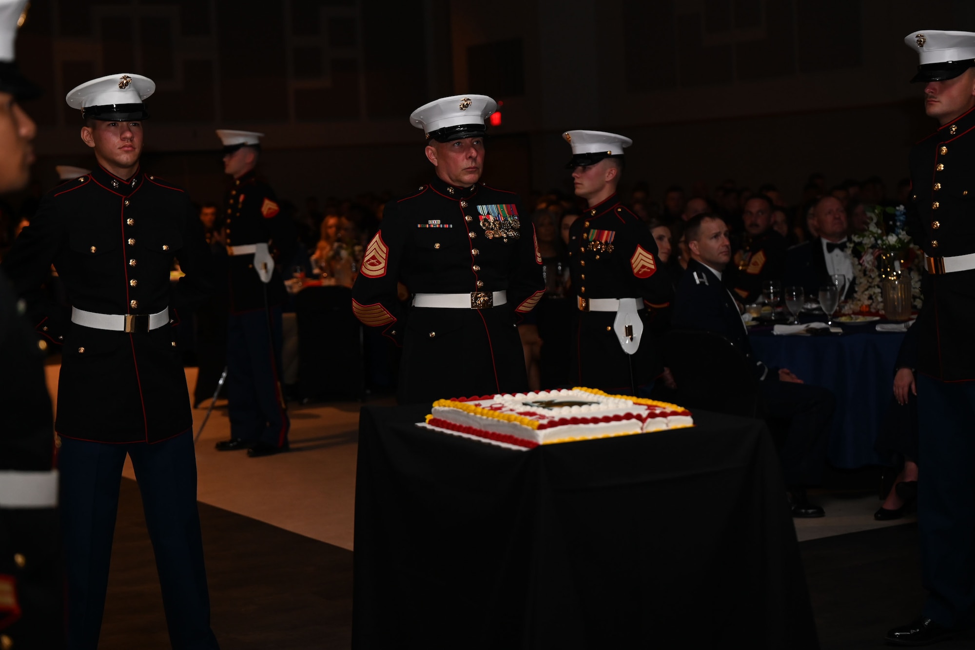 U.S. Marine Corps Gunnery Sgt. Patrick Pullman, center, oldest Marine in attendance, and Pvt. Kenneth Walker, left, youngest Marine in attendance, stand in the center aisle to receive a slice of cake as the youngest and oldest Marine during the 248th Marine Corps Birthday Ball at the McNease Convention Center, San Angelo, Texas, Nov. 10, 2023. The Marine Corps Birthday Ball is a time-honored tradition celebrating past, present, and future Marines. (U.S. Air Force photo by Airman 1st Class Evelyn J. D’Errico)