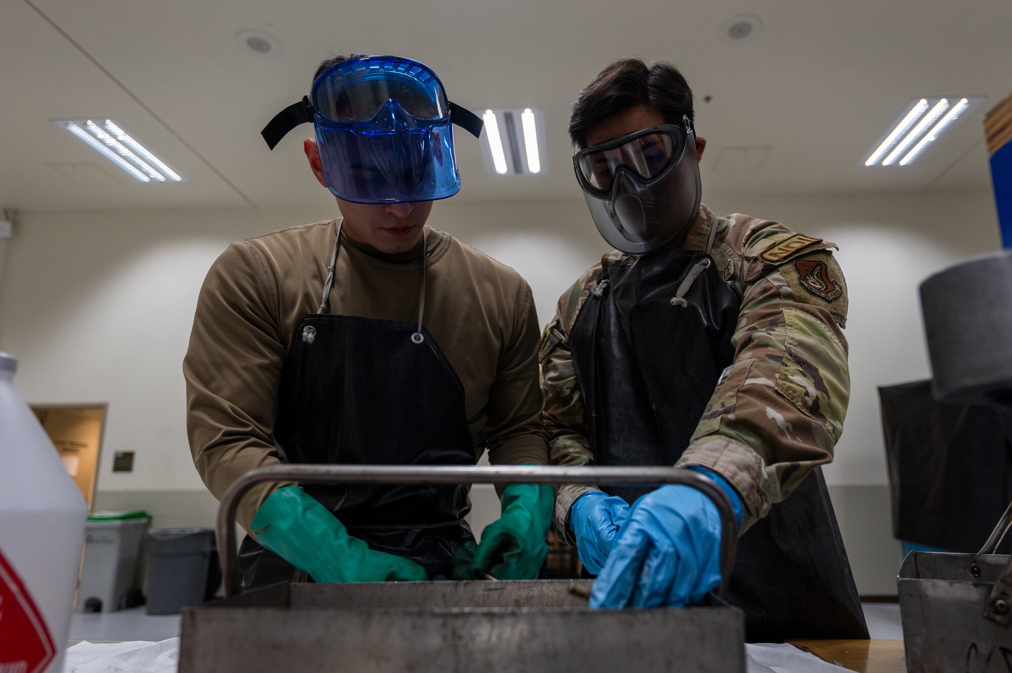 Senior Airman Mario Gomez and Senior Airman Daniel Del Rosario sort clean bolts before inspecting them.