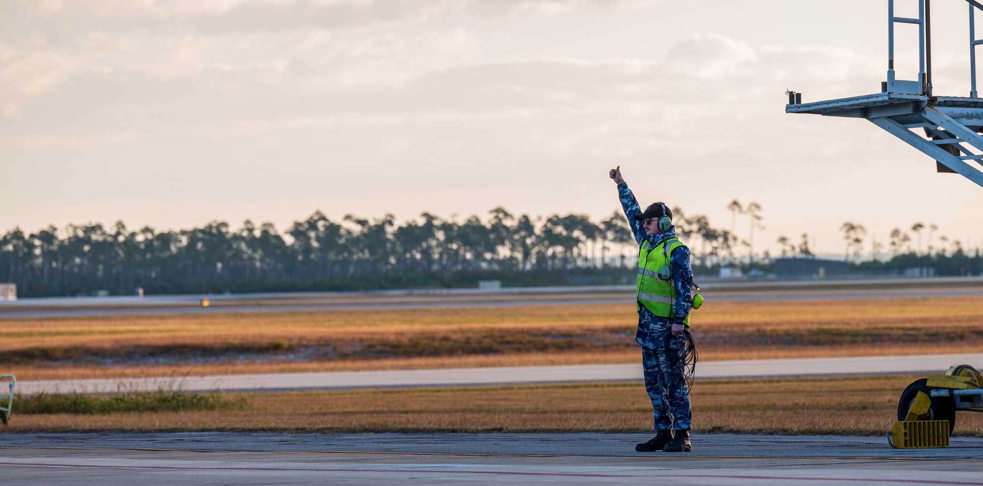 A Royal Australian Air Force aircraftman singles aircraft for taxi