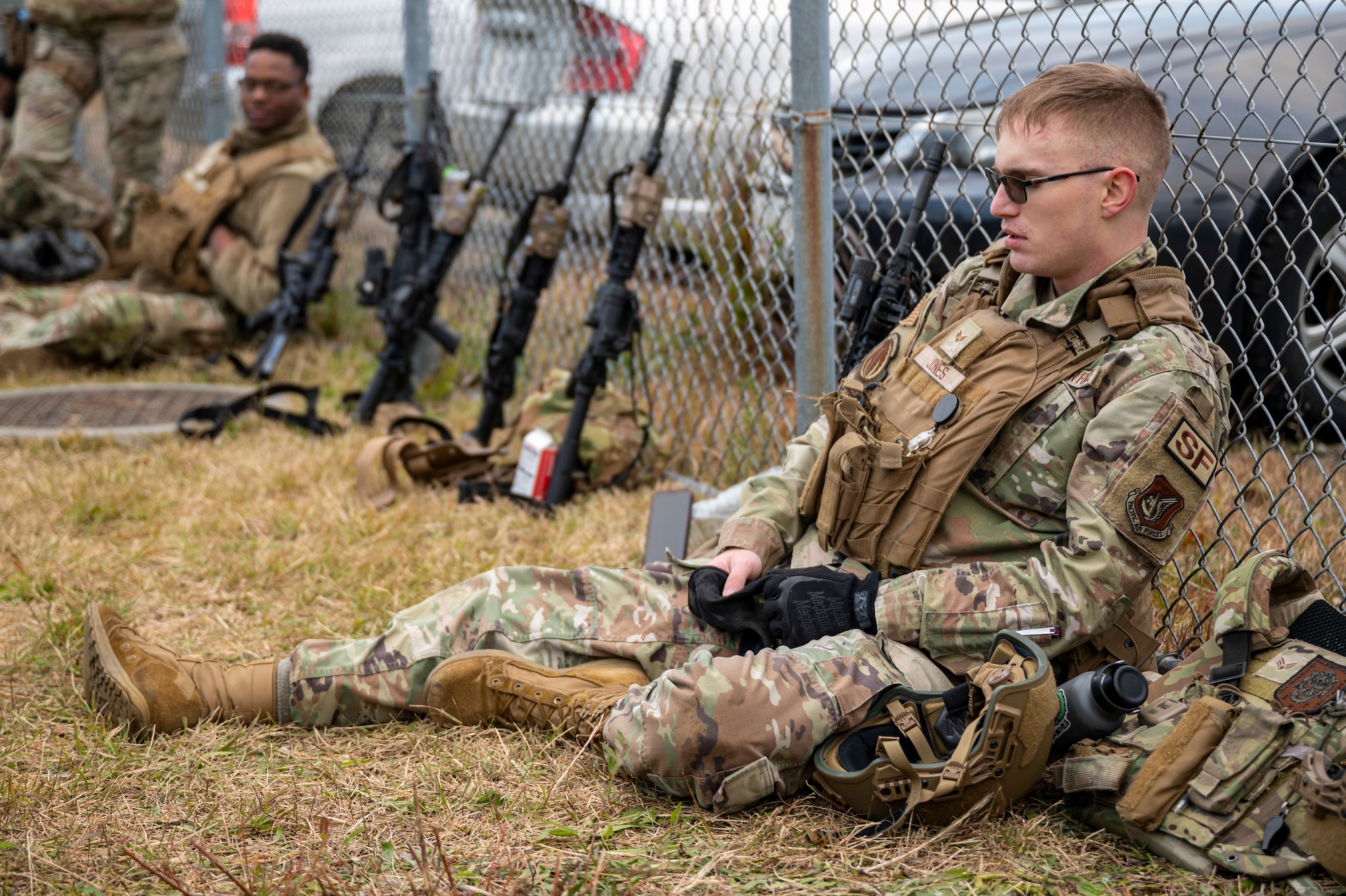 A Airman rest on a fence during a training.