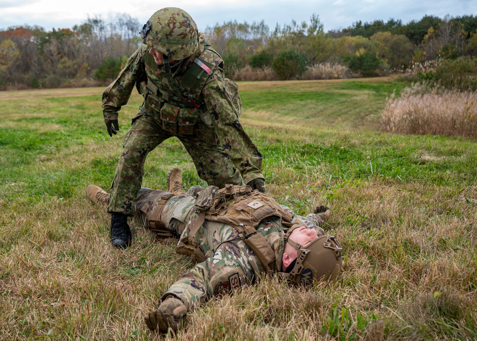Japanese service member provides medical aid to a simulated injured casualty.