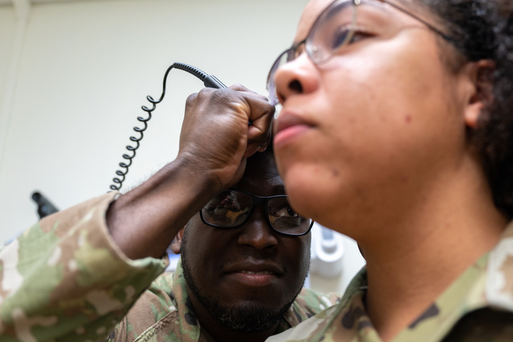Staff Sgt. Emanuel Lookadoo examines a patient's ear during a routine check-up.