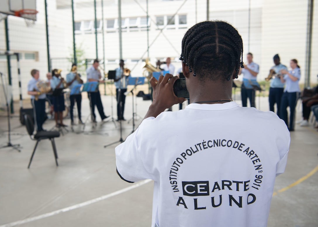 An Angolan student, from the Polytechnic Institute of Art in Kilamba, Angola, records U.S. Airmen with the U.S. Air Forces in Europe and Air Forces Africa (USAFE-AFAFRICA) Band’s 5 Star Brass and Angolan Armed Forces Band members performance in Kilamba, Nov. 9, 2023. The USAFE-AFAFRICA Band’s tour to Angola embodies the U.S. Air Forces Africa’s dedication to strengthening cultural ties and enriching the partnerships between the U.S. and Angola through music. (U.S. Department of Defense photo by Mass Communication Specialist 2nd Class Michael Hogan)