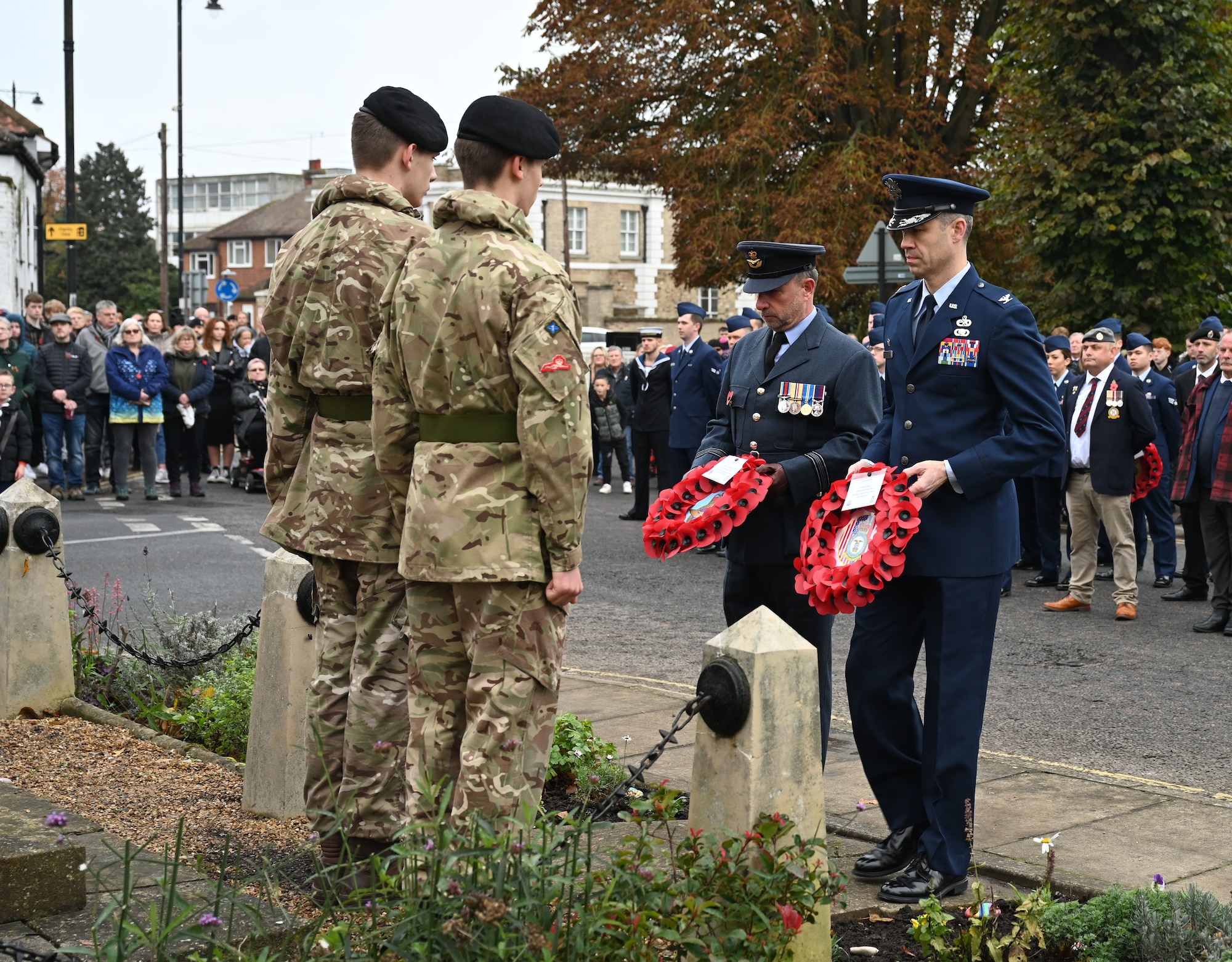 U.S. Air Force Col. Aaron Rivers, front right, 100th Maintenance Group commander, and Sqn Ldr Andy Bell, Royal Air Force commander, front second right, hand over poppy wreaths to British Army Cadets at the war memorial during a Remembrance Sunday parade in Mildenhall, Suffolk, England, Nov. 12, 2023. Two minutes silence was observed immediately after the playing of “The Last Post,” followed by Reveille. Team Mildenhall Airmen participated in Remembrance Sunday parades throughout the local area and East Anglia. The poppy was chosen as a symbol of remembrance and hope for a peaceful future in the aftermath of World War I, as a sign of support for the Armed Forces community. (U.S. Air Force photo by Karen Abeyasekere)