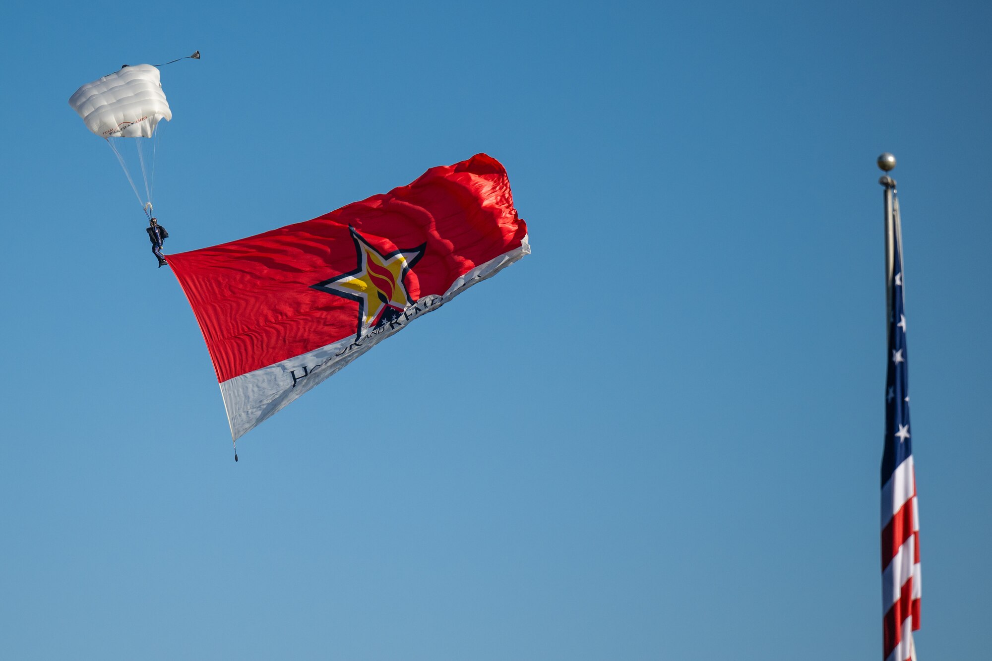 A parachutist skydives into Churchill Downs Racetrack in Louisville, Ky., Nov. 5, 2023, with the “Honor and Remember” banner as part of Survivor’s Day at the Races, an annual event to honor family members who've lost loved ones in military service to the United States. Hosted with assistance from the Kentucky National Guard, the event drew more than 700 family members from 18 states. (U.S. Air National Guard photo by Dale Greer)