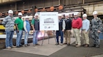 THE SUPSHIP Gulf Coast/Ingalls Shipbuilding team celebrated  the start of fabrication milestone for the future USS Thad Cochran (DDG 135) on Oct. 13. Code 150 members who took part in the ceremony were, from right, Lt. (AUS) Mitchell Van Donselaar, DDG superintendent; Ray Pelanne, Deputy Program Manager's Representative; and, at left, David Grafton, production controller.
