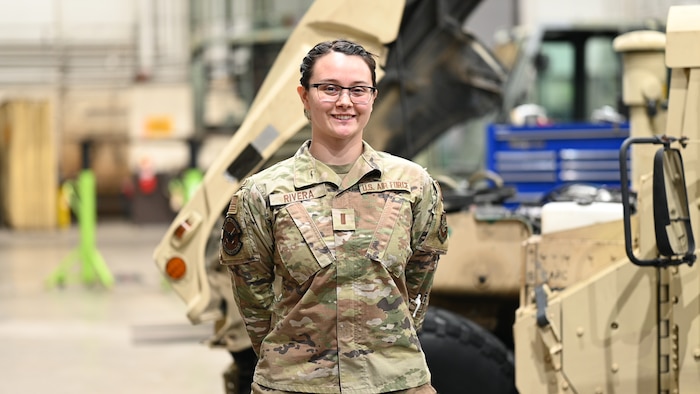 Airman stands in vehicle bay for photo.