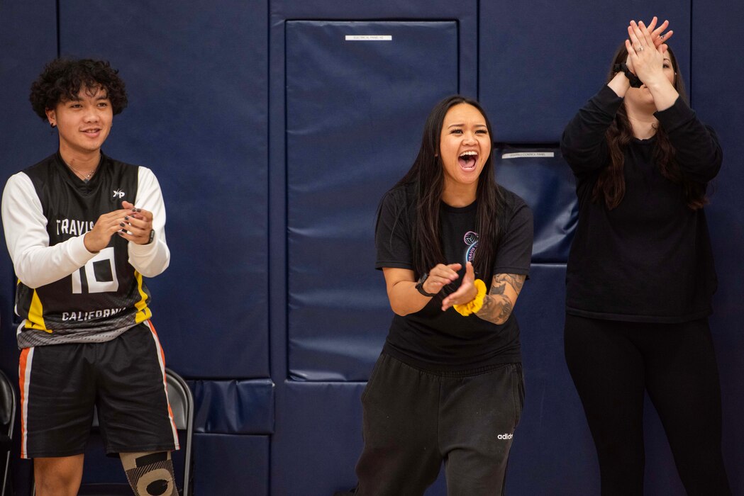 People cheer on the sidelines of a volleyball game.