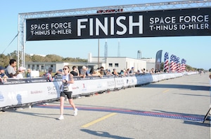 A female runner finishes the the inaugural United States Space Force T-Minus 10-Miler at Cape Canaveral Space Force Station, Fla.