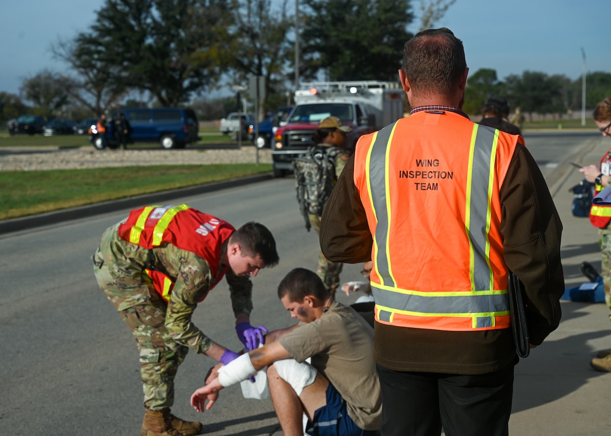 Chad Walden, 17th Training Wing, Wing Inspection Team, observes the 17th Medical Group treating simulated casualties during an exercise at Goodfellow Air Force Base, Texas, Nov. 16, 2023. The simulation allowed the WIT to evaluate security measures' effectiveness and identify improvement areas. (U.S. Air Force photo by Airman 1st Class Zach Heimbuch)