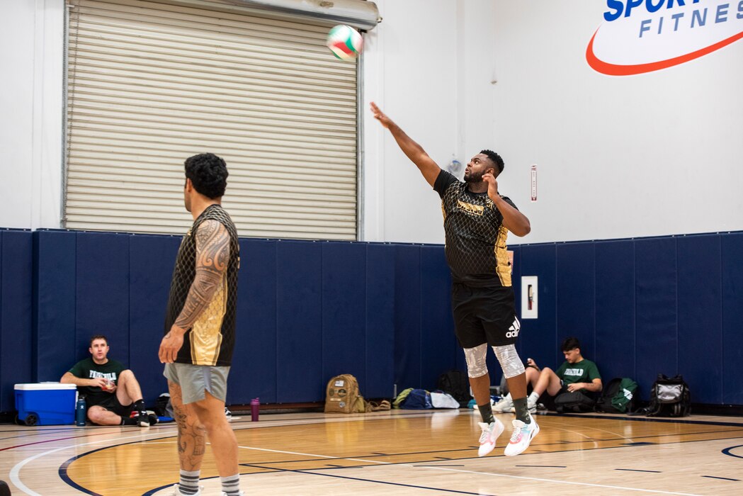 A volleyball player serves a volleyball.