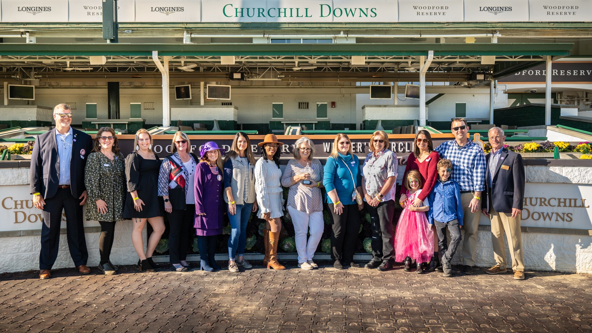 Family members who've lost loved ones in military service to the United States stand in the winner’s circle with a trophy for the victor of the 5th race at Churchill Downs Racetrack in Louisville, Ky., Nov. 5, 2023. The 5 1/2-furlong maiden contest, named the Race for Survivors of the Fallen Military Heroes, was won by Halina’s Forte, a 2-year-old filly, with jockey Martin Garcia aboard. The event, hosted with assistance from the Kentucky National Guard, was part of Survivor’s Day at the Races and drew more than 700 family members from 18 states. (U.S. Air National Guard photo bay Dale Greer)