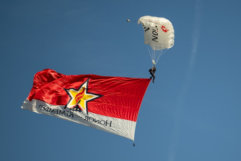A parachutists skydives into Churchill Downs Racetrack in Louisville, Ky., Nov. 5, 2023, with the “Honor and Remember” banner  as part of Survivor’s Day at the Races, an annual event to honor family members who've lost loved ones in military service to the United States. Hosted with assistance from the Kentucky National Guard, the event drew more than 700 family members from 18 states. (U.S. Air National Guard photo bay Dale Greer)