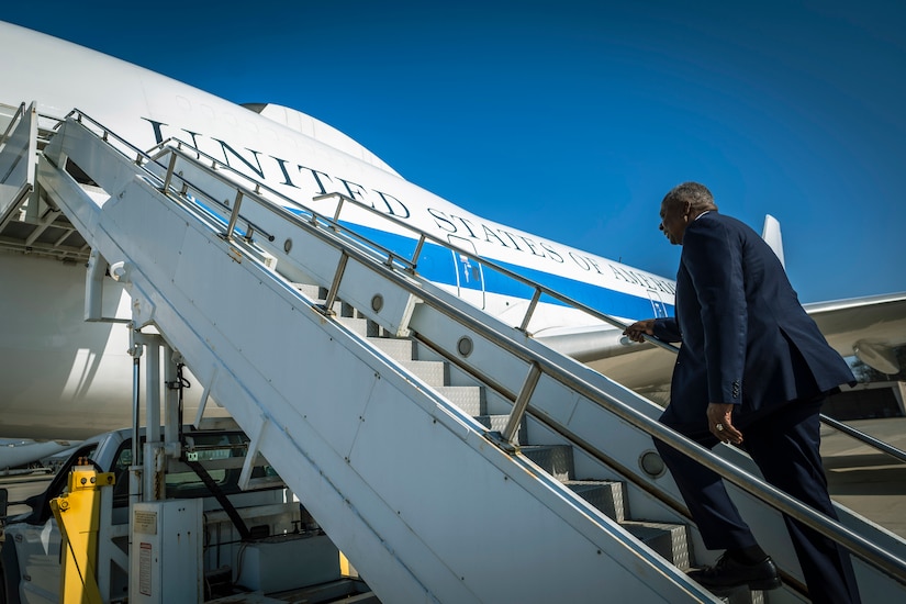 A person in a suit boards a plane.