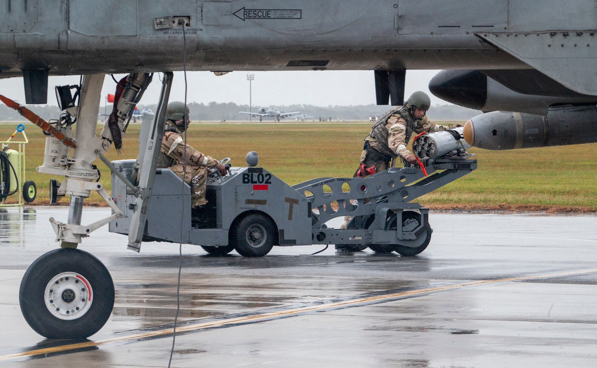 U.S. Air Force Senior Airman Howell Marian (left), 74th Fighter Generation Squadron weapons load crewmember, and U.S. Air Force Staff Sgt. David Walker (center), 74th FGS weapons load team chief, transport a bomb at Avon Park Air Force Range, Florida, Nov. 15, 2023. During an integrated combat turn, rearming and refueling is done simultaneously to get the aircraft back in the air as quickly as possible. (U.S. Air Force photo by Airman 1st Class Leonid Soubbotine)
